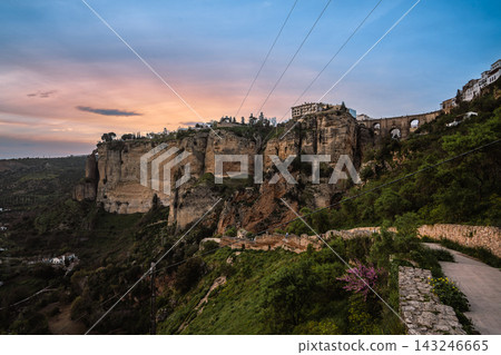 Dramatic limestone cliffs of Ronda with Puente Nuevo bridge at pink sunset Dramatic limestone cliffs of Ronda with Puente Nuevo bridge at pink sunset 143246665