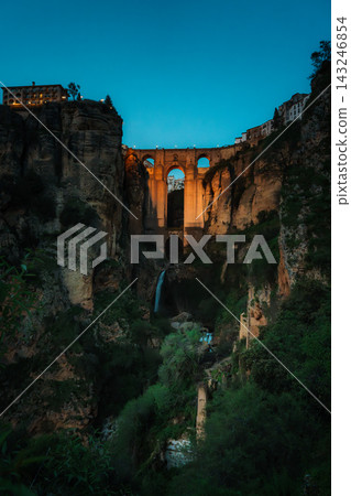 Illuminated Puente Nuevo bridge over El Tajo gorge in Ronda at blue hour Illuminated Puente Nuevo bridge over El Tajo gorge in Ronda at blue hour 143246854