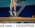 Close up female gymnast jumping above balance beam 143247026