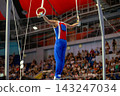 Male russian gymnast performing iron cross on still rings 143247034