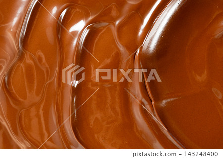 Swirling melted milk chocolate background with glossy wave texture Swirling melted milk chocolate background with glossy wave texture 143248400