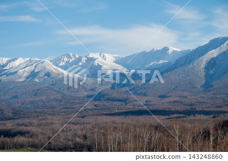 Tokachidake, a forest and snow-capped mountains on a sunny day in late autumn Tokachidake, a forest and snow-capped mountains on a sunny day in late autumn 143248860