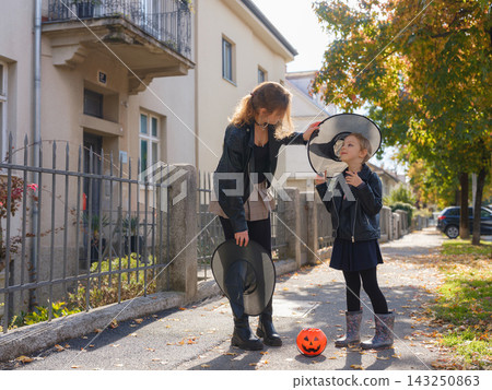 Mother and daughter enjoying Halloween trick or treat in neighborhood Mother and daughter enjoying Halloween trick or treat in neighborhood 143250863