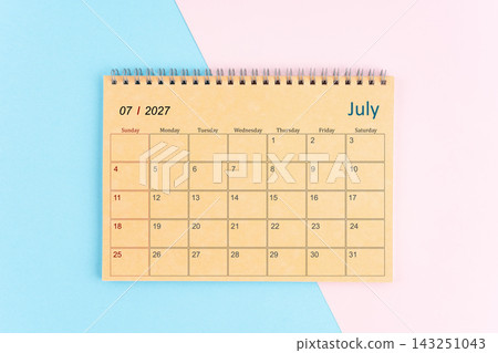 July 2027 craft brown paper calendar on pink and blue background. July 2027 craft brown paper calendar on pink and blue background. 143251043