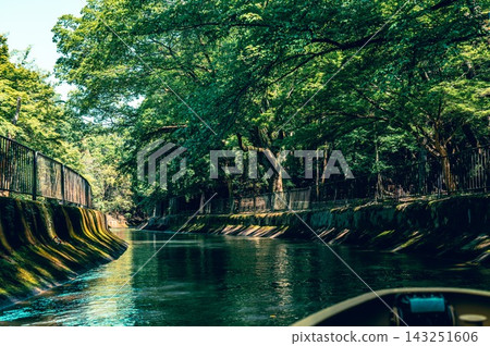 A view of the green arch and calm waters from the bow of a boat on the Lake Biwa Canal. A view of the green arch and calm waters from the bow of a boat on the Lake Biwa Canal. 143251606
