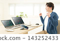 A man in his 20s makes a triumphant gesture while looking at stock charts at home. 143252433