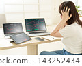 A young woman holds her head in her hands as she looks at the downward trend charts displayed on multiple devices. 143252434