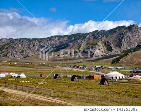 Panoramic landscape view of traditional Mongolian yurts or gers clustered in a tourist camp surrounded by rolling green hills in Gorkhi-Terelj National Park, Mongolia Panoramic landscape view of traditional Mongolian yurts or gers clustered in a tourist camp surrounded by rolling green hills in Gorkhi-Terelj National Park, Mongolia 143253392