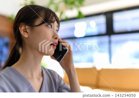 A woman giving advice while talking on her smartphone. A woman giving advice while talking on her smartphone. 143254050
