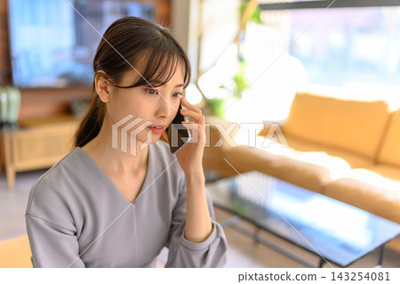 一名女子正在用智慧型手機與人通話。 一名女子正在用智慧型手機與人通話。 143254081