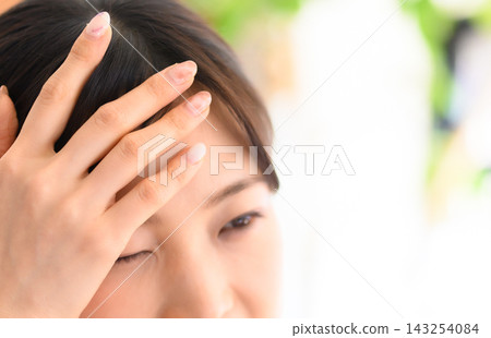 A woman's face and hand winking with one eye. A woman's face and hand winking with one eye. 143254084