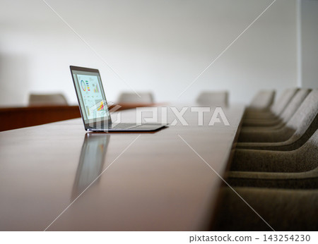 一台筆記型電腦放在會議室的桌子上,電腦螢幕上顯示一張圖表。 一台筆記型電腦放在會議室的桌子上,電腦螢幕上顯示一張圖表。 143254230