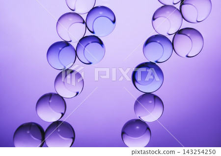 Transparent spheres creating an abstract chains pattern with reflections on purple background Transparent spheres creating an abstract chains pattern with reflections on purple background 143254250