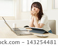 A young woman with an anxious expression as she looks at the computer screen. 143254481