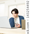 A young male business person thinking seriously while working on his laptop. 143254492