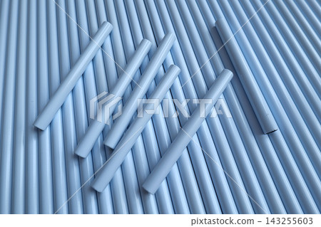Hand holding white plastic pipes against a background of more pipes 143255603