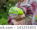 Person holding a green anti stress squishy toy with a giant popped bubble forward to the camera. Trendy fidget toys and stress management concept 143255855