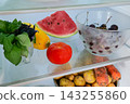 Fresh summer vegetables and fruits stored on a refrigerator shelf 143255860
