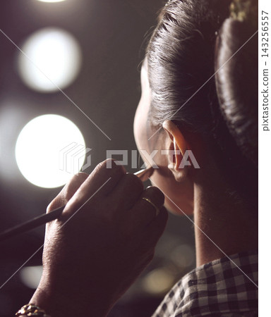Makeup Artist Applying Finishing Touches To Model Backstage In Dressing Room With Vanity Lights 143256557