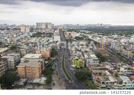 An elevated panoramic view shows dense low-rise neighborhoods and distant apartment towers beneath a broad overcast sky. An elevated panoramic view shows dense low-rise neighborhoods and distant apartment towers beneath a broad overcast sky. 143257220