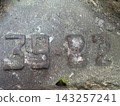 Weathered stone surface featuring the carved numbers thirty nine and eighty two 143257241