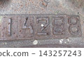 Close up of embossed metal number plate with heavy rust texture 143257243