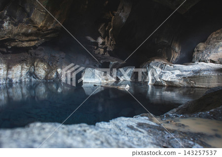 Grjotagja geothermal cave with blue water and steam in Iceland 143257537