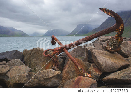 Large rusty anchor on a rocky pier in Flateyri, Iceland Large rusty anchor on a rocky pier in Flateyri, Iceland 143257583