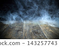 Smoke swirling on dark wooden surface creating mystery 143257743