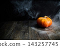 Pumpkin on wooden table creating spooky smoke effect 143257745