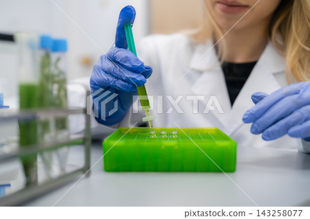 Filtering of plant extracts using syringe filters into HPLC vial in green box. Clean environment with glassware and lab equipment visible in the background. Filtering of plant extracts using syringe filters into HPLC vial in green box. Clean environment with glassware and lab equipment visible in the background. 143258077