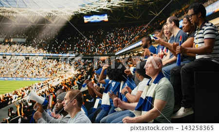 Black father spending quality weekend time with son at packed soccer stadium full of cheering fans. Football family lifestyle, parenthood and family bonding, blue team support and childhood joy. Black father spending quality weekend time with son at packed soccer stadium full of cheering fans. Football family lifestyle, parenthood and family bonding, blue team support and childhood joy. 143258365