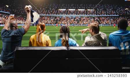 Soccer supporters watch live match from sofa at home, being transported to stadium field. Enthusiastic football fans feeling immersive live sports experience energy 143258393