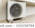 Air conditioner outdoor unit placed under a bay window in the hallway of an apartment building 143258794