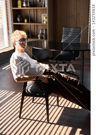 Male figure seated peacefully amidst brightly lit office setting Male figure seated peacefully amidst brightly lit office setting 143258838