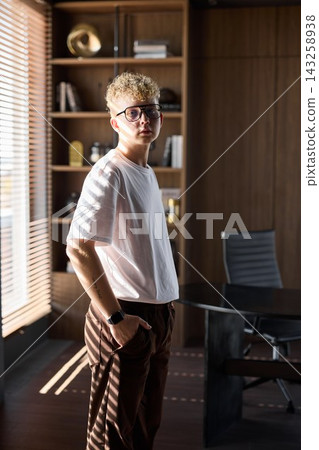 Male figure with thoughtful expression beside decorative shelves 143258938