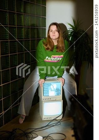 Young female artist surrounded by retro television art display 143258939