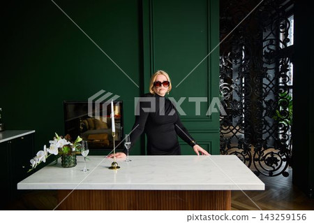 Caucasian woman modern host entertaining at marble bar Caucasian woman modern host entertaining at marble bar 143259156