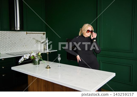 Caucasian woman fashion consultant adjusting sunglasses in luxury kitchen Caucasian woman fashion consultant adjusting sunglasses in luxury kitchen 143259157