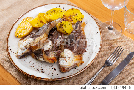 On white plate-grilled beef ribs garnished with fried potatoes On white plate-grilled beef ribs garnished with fried potatoes 143259466