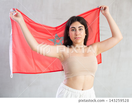 Young woman with flag of Morocco posing in studio Young woman with flag of Morocco posing in studio 143259528