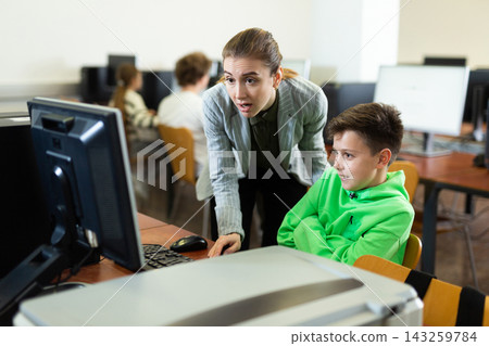 Teacher together with students conduct lesson on computer education Teacher together with students conduct lesson on computer education 143259784