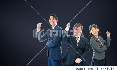 三名辦公室工作人員，兩男一女，在黑色背景下舉起拳頭，左側留有空白。 143261017