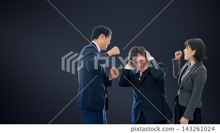 A boss holding his head in his hands, confronted by a subordinate against a dark background – an image of moral harassment. A boss holding his head in his hands, confronted by a subordinate against a dark background – an image of moral harassment. 143261024