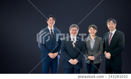 Four smiling business people are lined up on the right side against a dark background, with a blank space on the left. Four smiling business people are lined up on the right side against a dark background, with a blank space on the left. 143261032