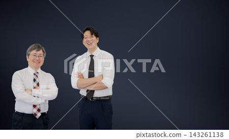 兩名身穿襯衫的商人雙手交叉放在胸前，站在深色背景的右側空白處。 143261138