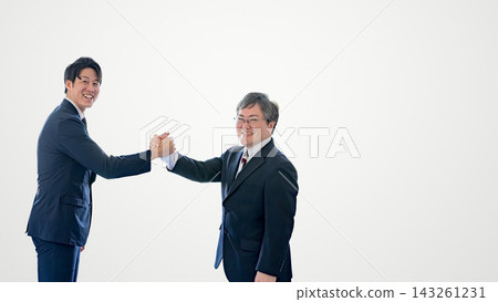 兩名日本商人面帶微笑,手牽手,背景是白色,右側留有空白區域。 兩名日本商人面帶微笑,手牽手,背景是白色,右側留有空白區域。 143261231