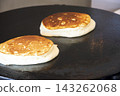 making thick pancakes on  griddle. 143262068
