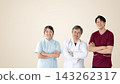 A medical team of doctors and nurses stands with their arms linked and smiling against a beige background. 143262317