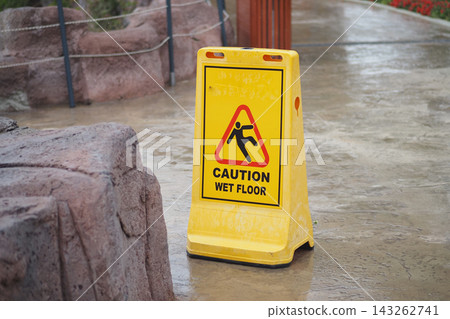 Caution sign alerts visitors about wet floor in a public area Caution sign alerts visitors about wet floor in a public area 143262741